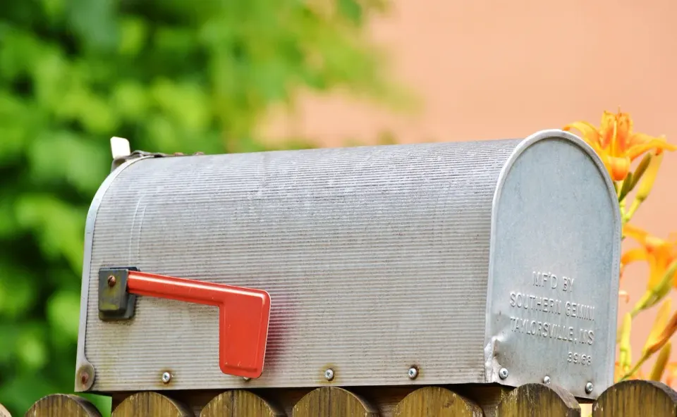 A metal American mailbox outside a home