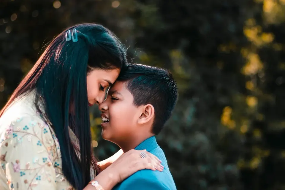A mother hugging her young son at home
