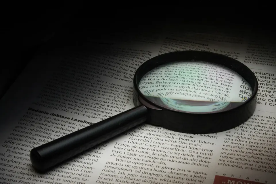 A magnifying glass resting on printed pages
